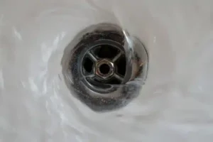 A close-up of water forming a whirlpool as it drains, showcasing Plumbing and Heating by Craig’s efficient sink drainage service.